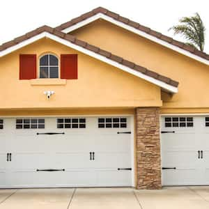 The exterior of a house with carriage style garage doors