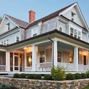 The exterior of a house with outdoor lighting and a lanscaped garden