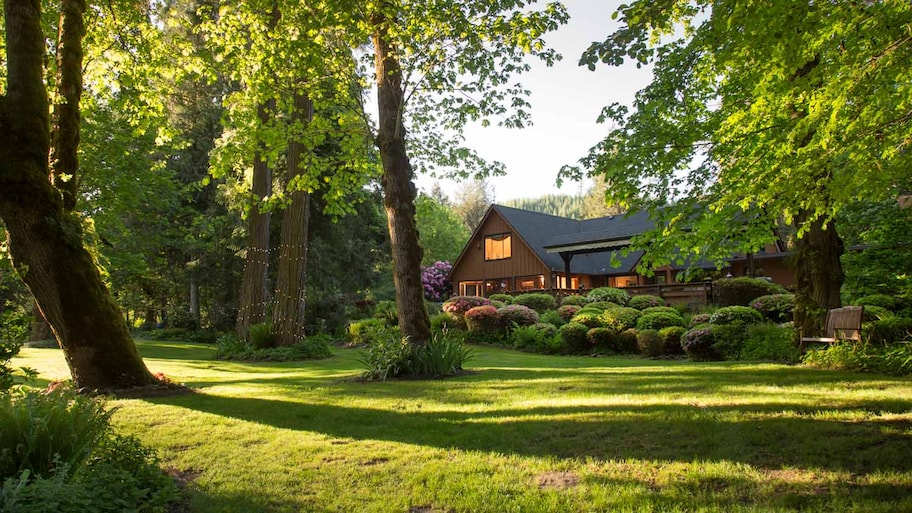 The facade of a house with lush gardens