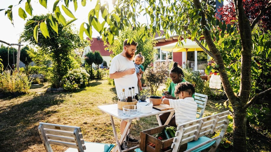 A family of four spending time around a table in their garden