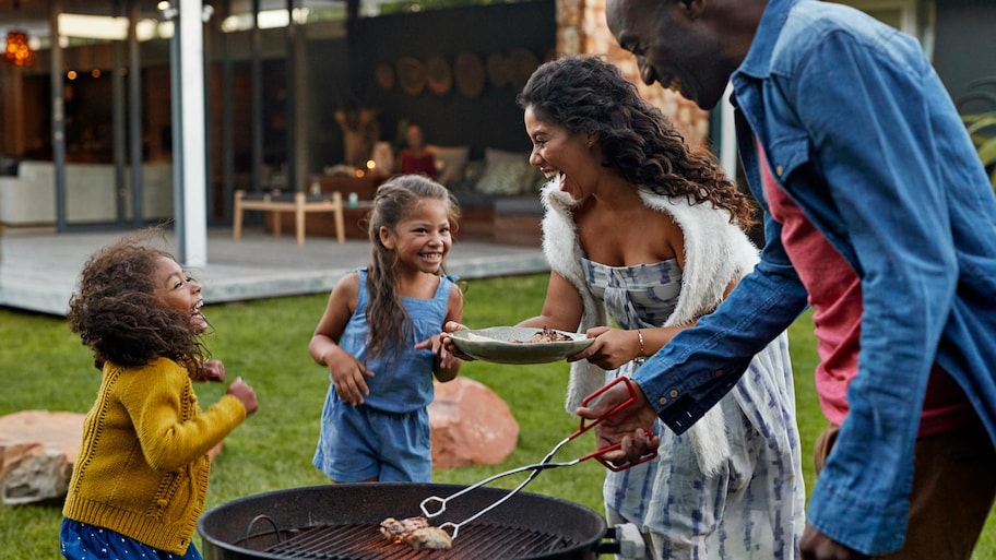 A family of four grilling their backyard