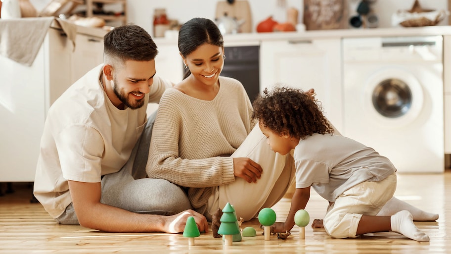 Parents playing with their son on the kitchen floor