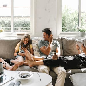 A family of four relaxing on the sofa in their living room