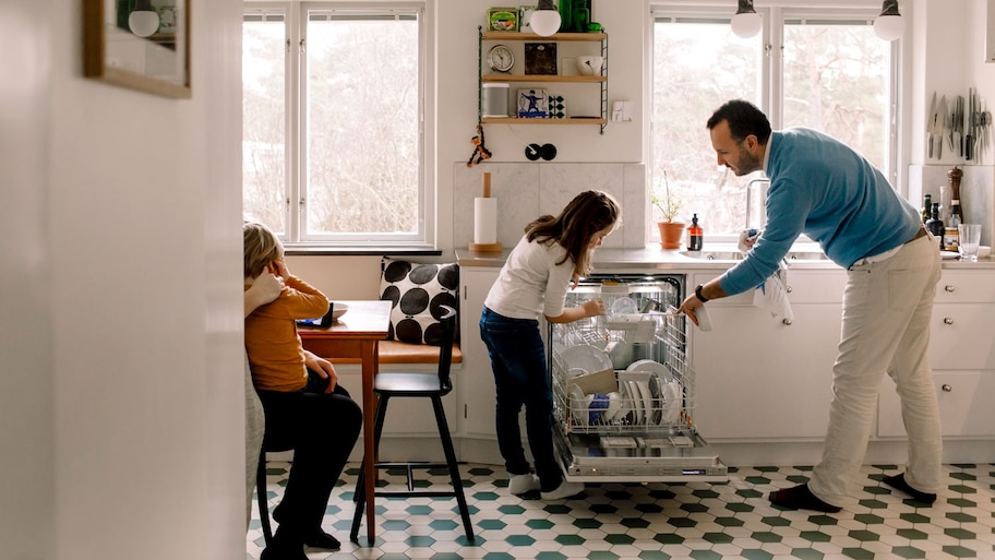 A father with his daughter loading the dishwasher