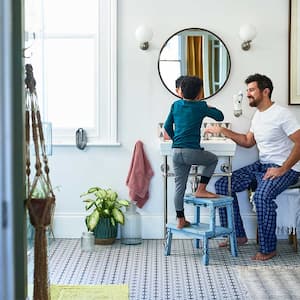 Father helping son brushing teeth in the bathroom