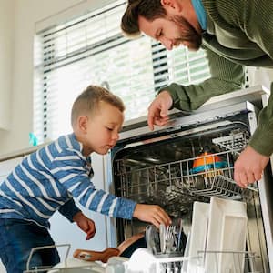 A father and his son loading the dishwasher