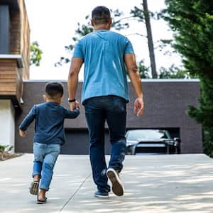 A father and his son walking up a driveway
