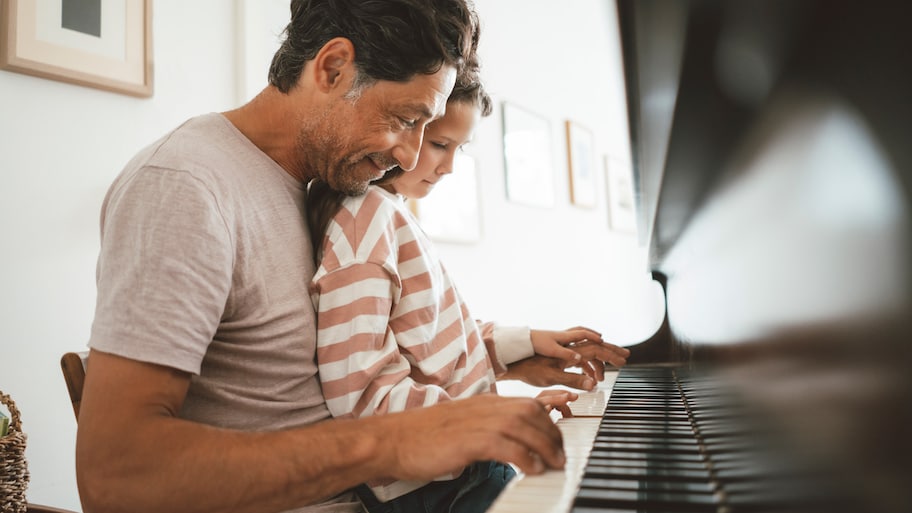 Father and daughter playing the piano.