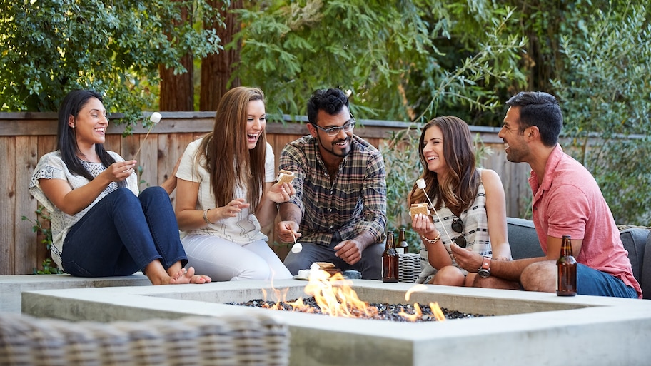 friends hanging out by large outdoor fire pit 