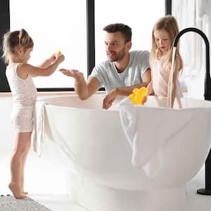Father and daughters filling bathtub with water