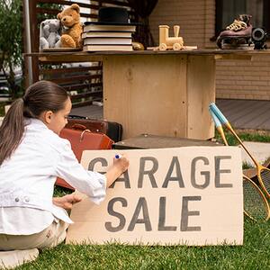 Little girl makes a garage sale sign