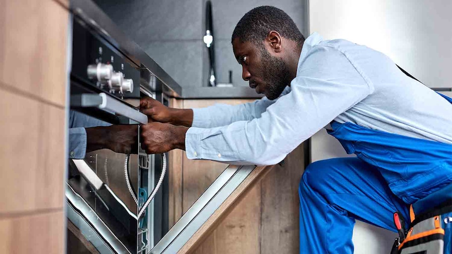 professional handyman working on dishwasher