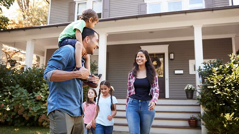 Happy family in front of house