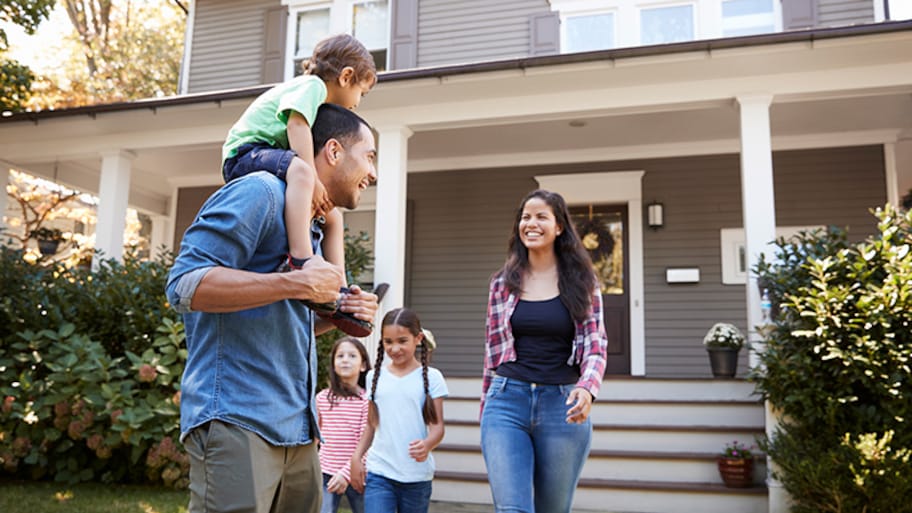 Happy family in front of house