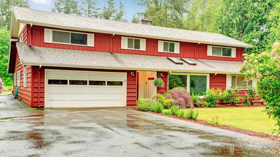 Red siding house with a wet driveway