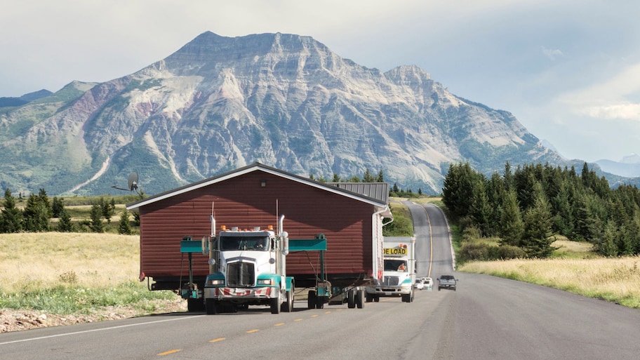 House being moved by semi trailer down the highway