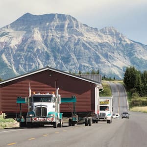 House being moved by semi trailer down the highway