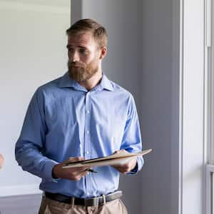 An inspector discusses with couple at their house