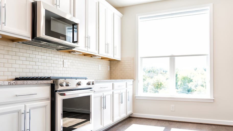 A kitchen interior with a microwave above the gas stove