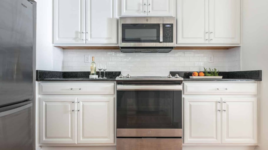 A kitchen with kitchen white cabinets and appliances