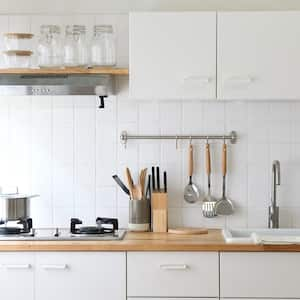 A modern kitchen with white cabinets and wooden countertop