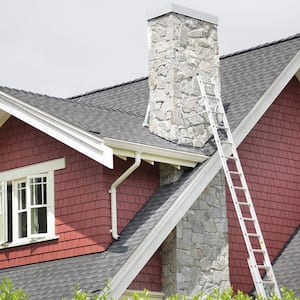 Ladder propped up on chimney of house