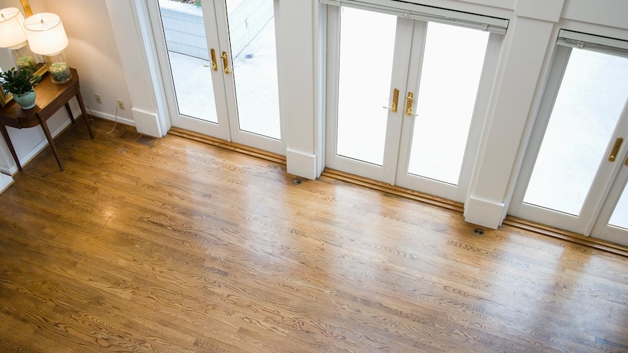 An empty living room with laminate flooring