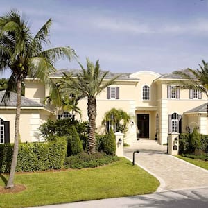 House in a tropical setting surrounded by palm trees