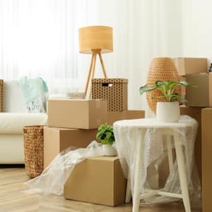 A living room with couch, moving boxes, and packing materials