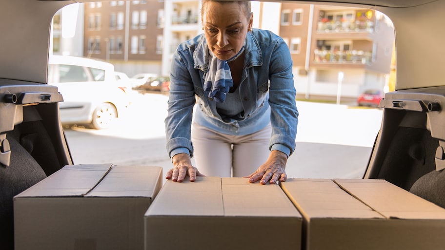 Woman arranging moving boxes in the car