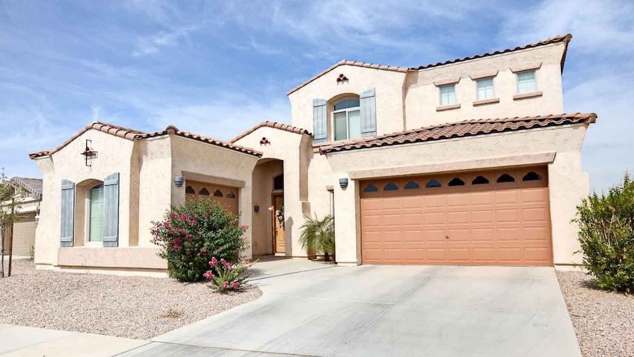 Luxury stucco house exterior with concrete driveway