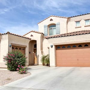 Luxury stucco house exterior with concrete driveway