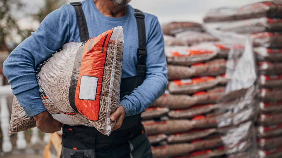 A man carrying a bag of pellets