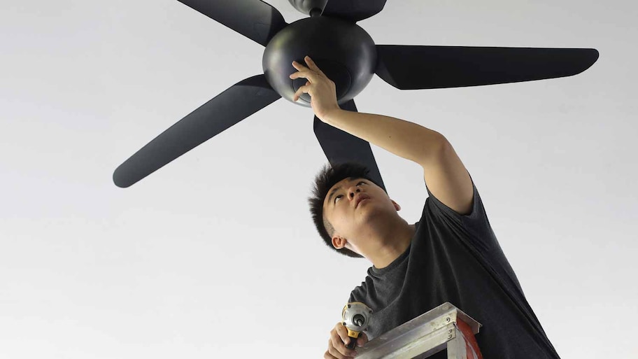 man checking ceiling fan