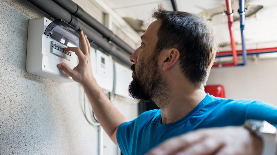 A man inspecting electrical in a house’s basement