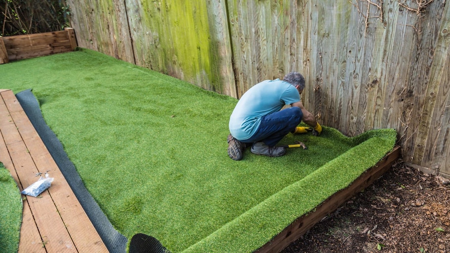 A man installing artificial lawn