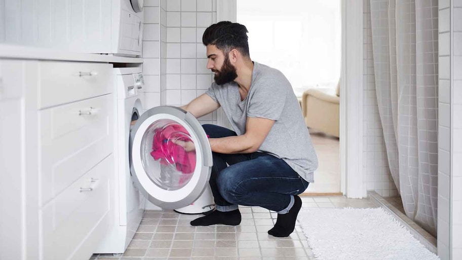 Man putting a new load in the dryer