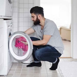 Man putting a new load in the dryer