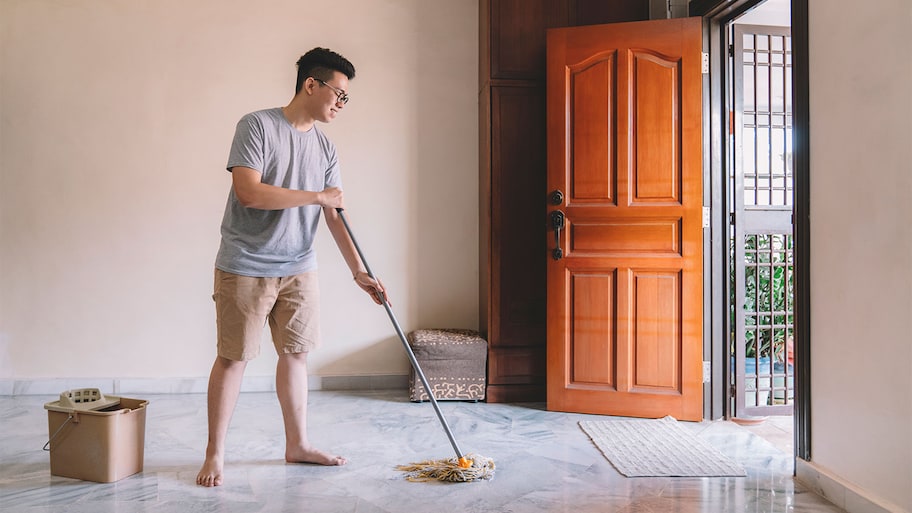 man mopping marble floors in home 