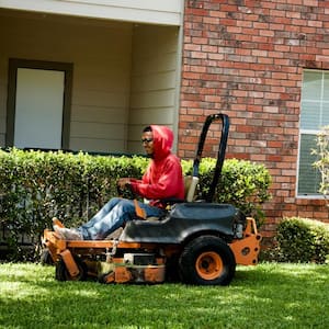 A man mowing the lawn using an industrial mower