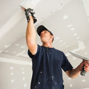 Man patching drywall ceiling