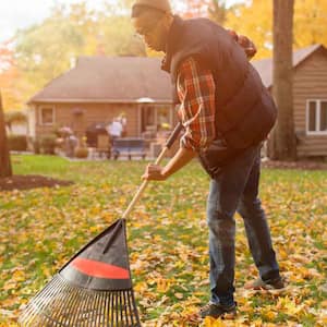 A man raking his yard during fall