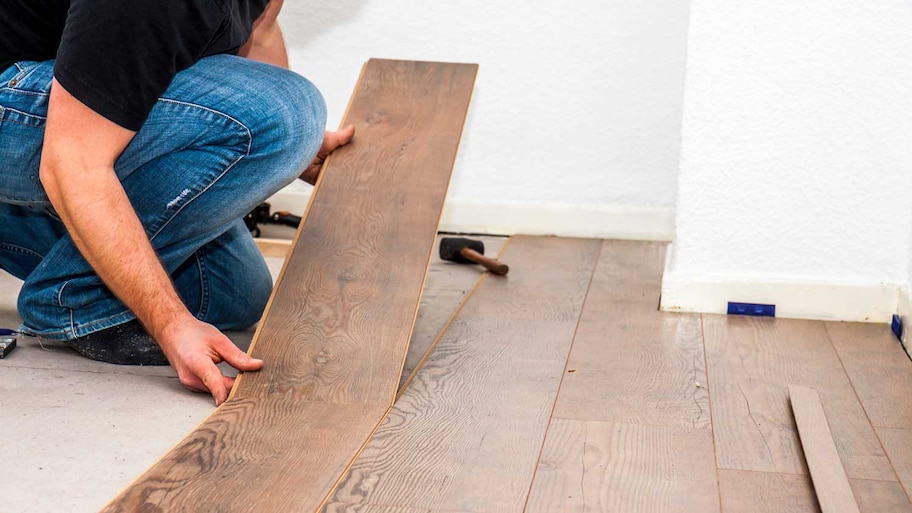 A man removing laminate flooring