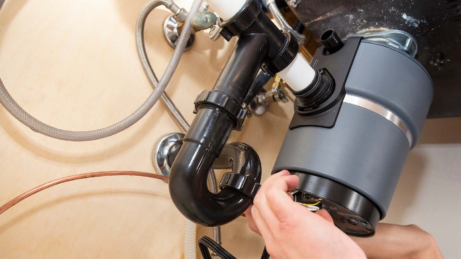 A man repairing a garbage disposal