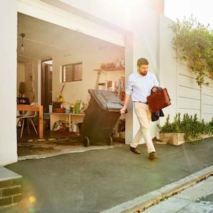 A man taking the trash out of the garage