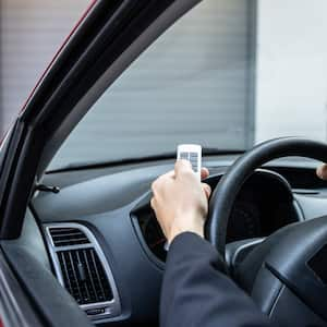 A man using a remote control to open her garage door