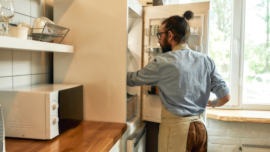 Man opening up refrigerator door