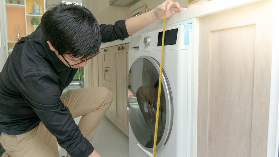 man measuring washing machine height