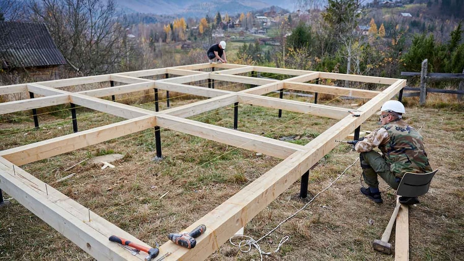 Two men building a pier-and-beam foundation