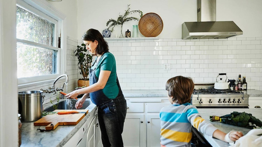 Mom cooks dinner with son in beautiful kitchen